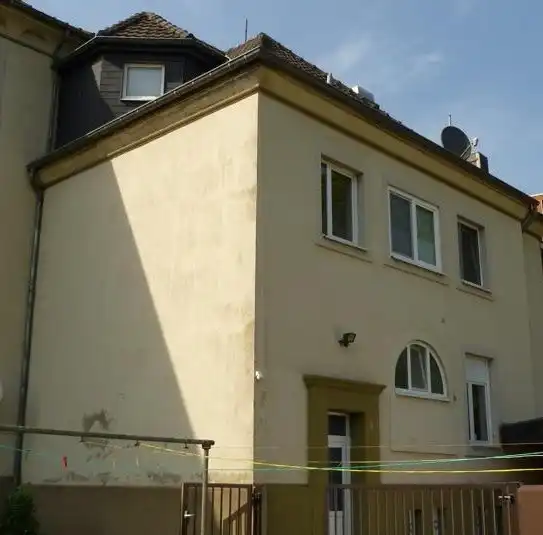 Altbaufassade mit verblichener, fleckiger Farbe