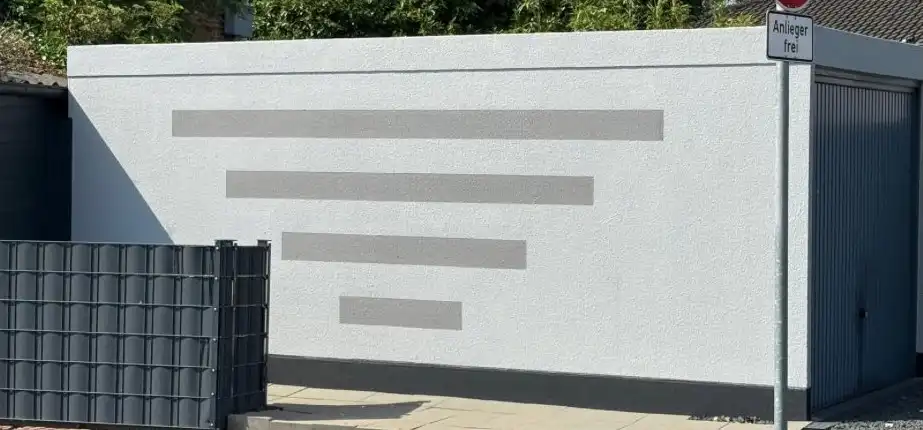 Garagenwand nach dem Anstrich mit grauen Streifen als Akzent