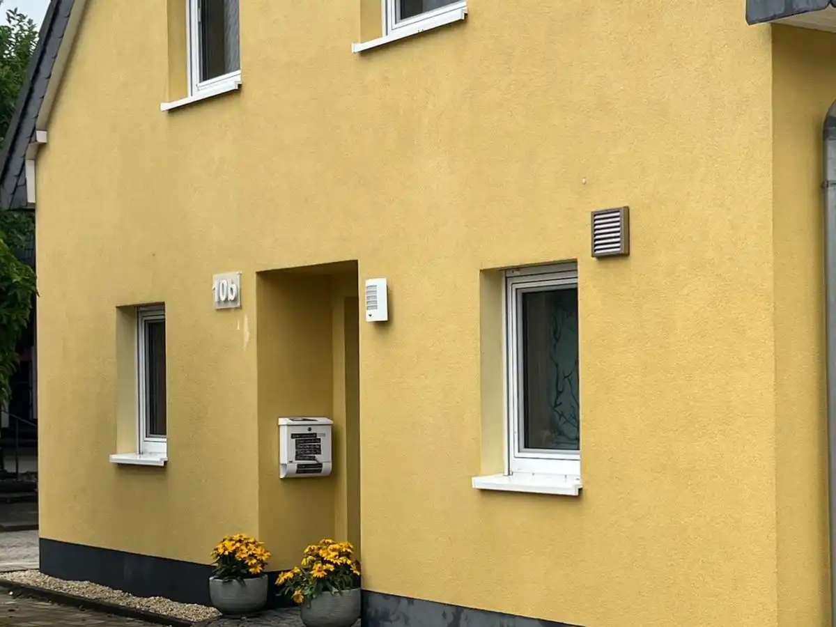 Gelbes Einfamilienhaus nach der Fassadenreinigung