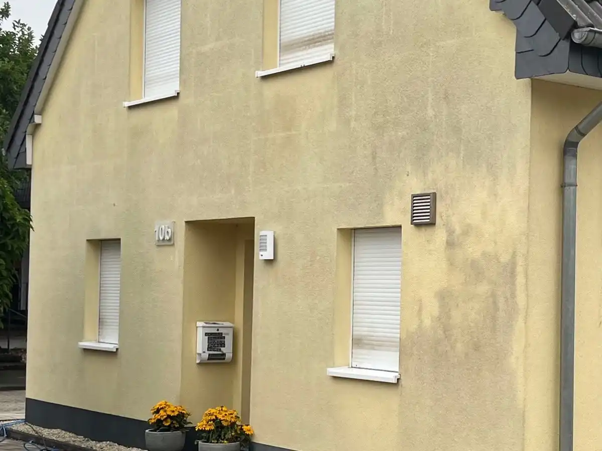 Gelbes Einfamilienhaus vor der Fassadenreinigung