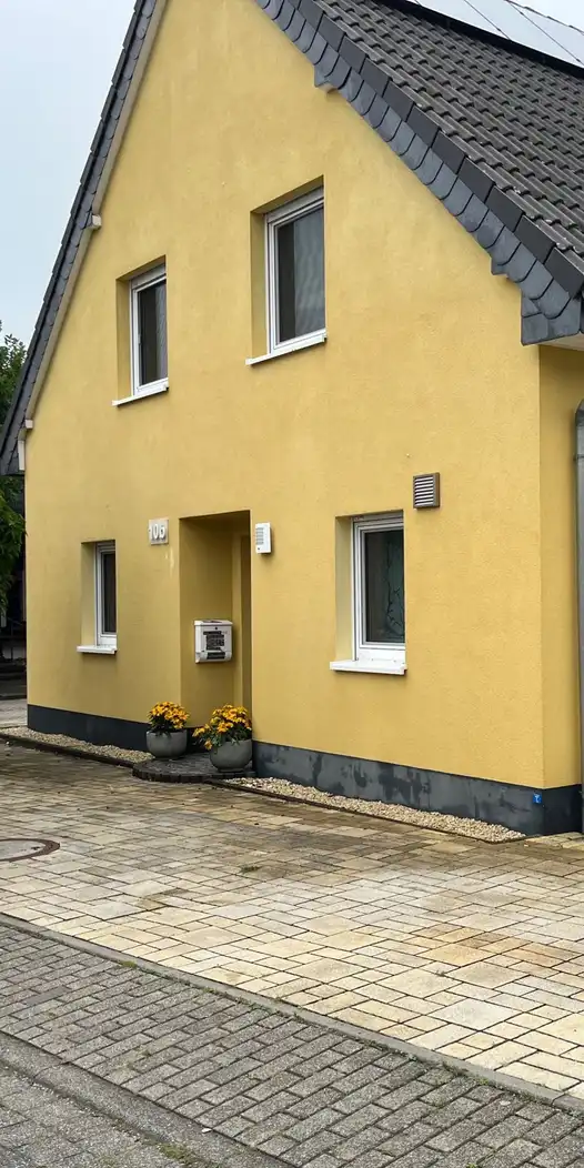 Gelbes Einfamilienhaus mit frisch gereinigter Fassade